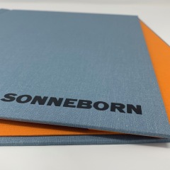 Exposed Screw Post Portfolio covered in Coated Sky Blue and Lined in Orange with Black Foil Stamping